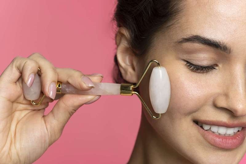 Massage mặt bằng đá thạch anh với các động tác lăn và miết nhẹ trên da.