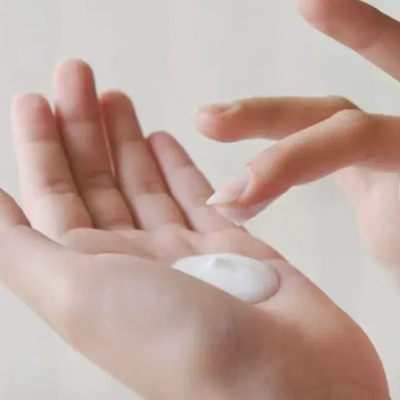 Lấy một lượng kem dưỡng thể vừa đủ ra lòng bàn tay